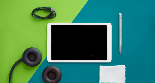 Selection of travel tech devices including tablet and headphones