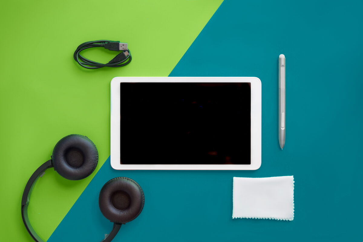 Selection of travel tech devices including tablet and headphones