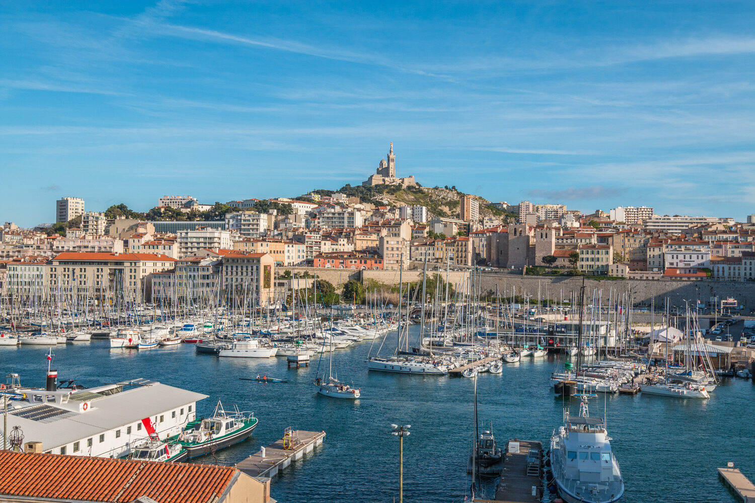 Marseille Harbour with blue sky in background and water and boats in foreground
