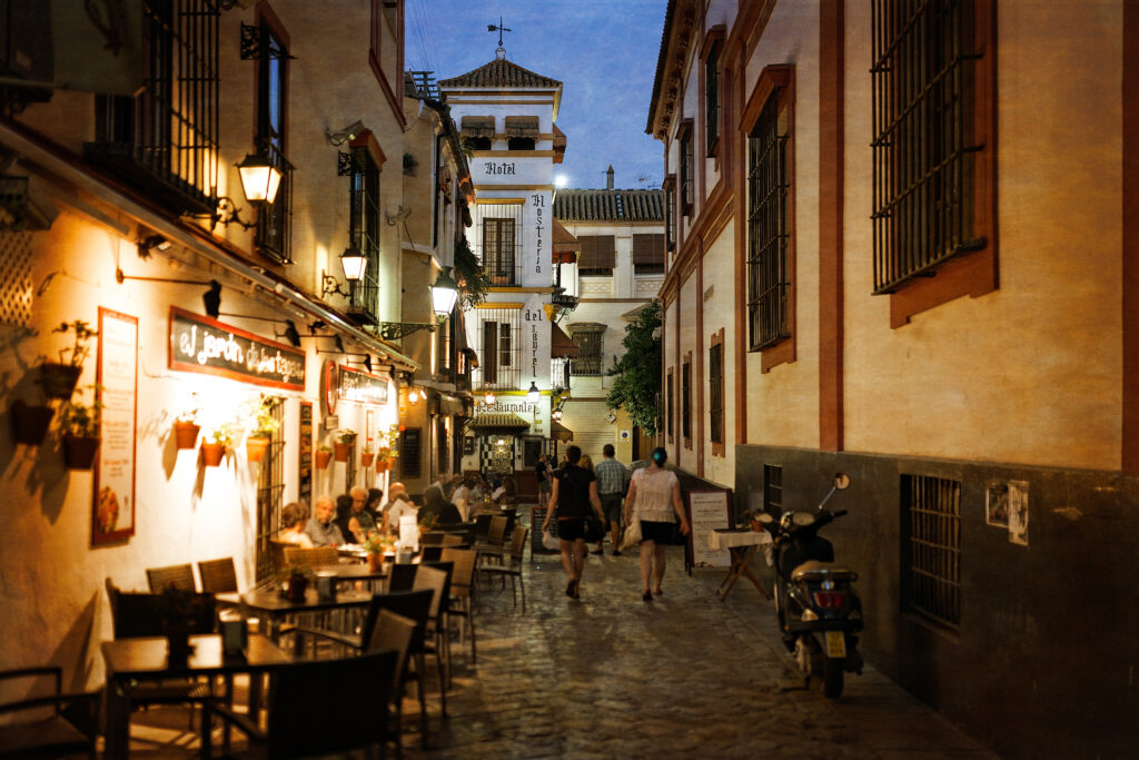 A dimly lit alleyway with cobblestones and traditional buildings in the background.