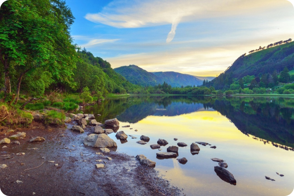 Mountains, valleys and a lake, with blue sky in background