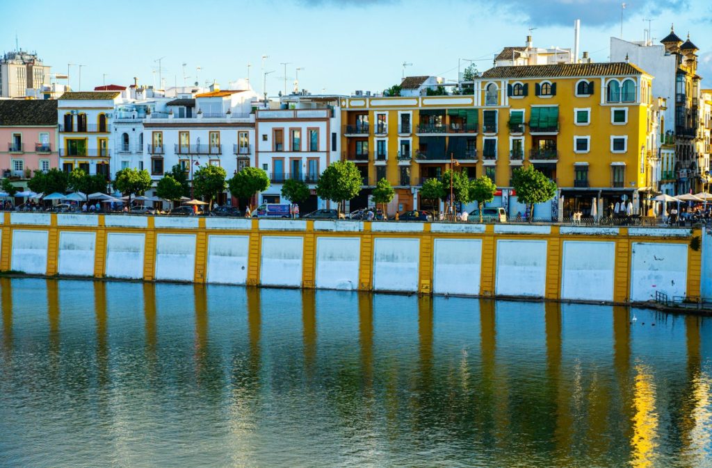 Colourful houses lining the edge of a river, blue sky in the background