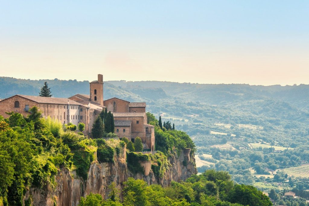 Medieval hillside town in Italy, with landscape and blue sky in background