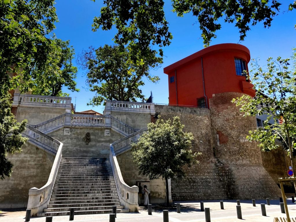Stone steps with trees and blue sky, and an historic tower in the background