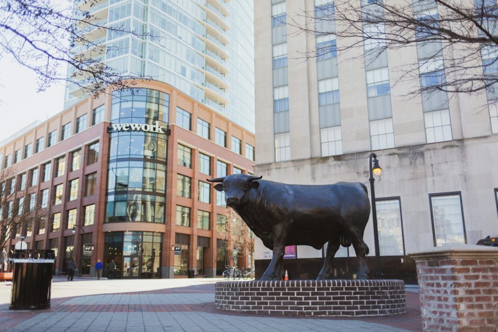 Bronze statue of a bull with a streetscape in the background