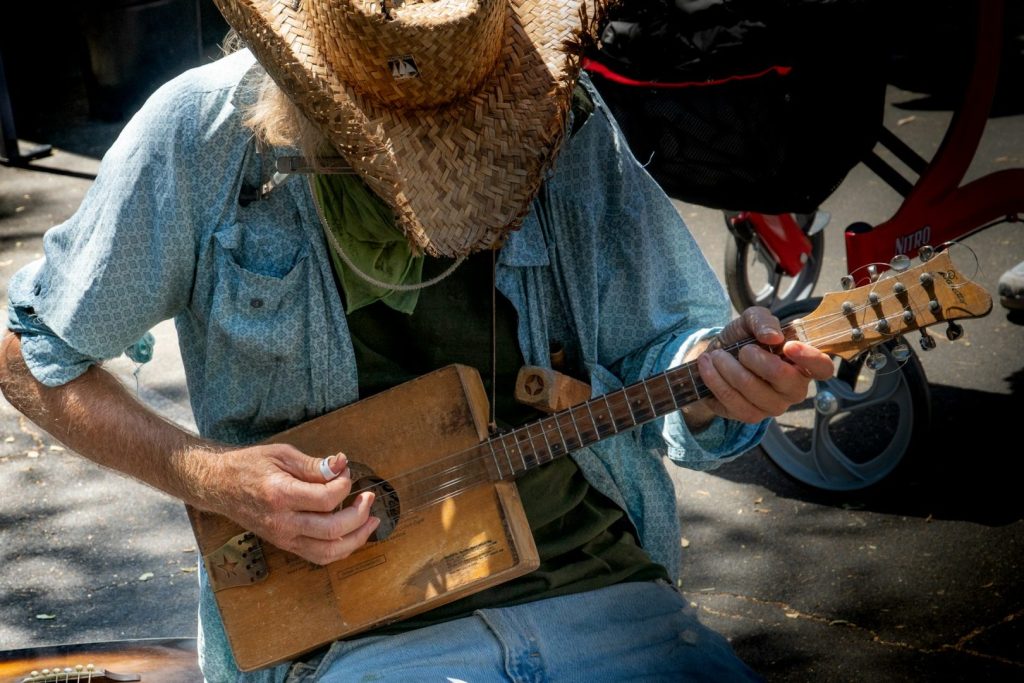 Musician in a hat with a string instrument playing bluegrass