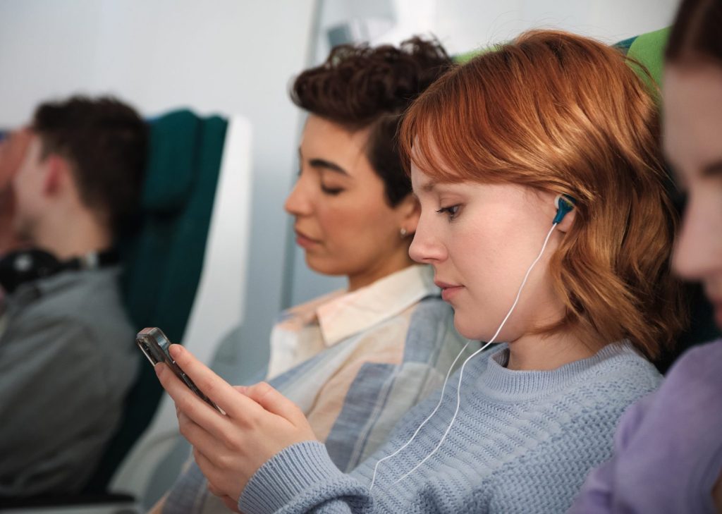 A passenger on board an airplane looking at her phone