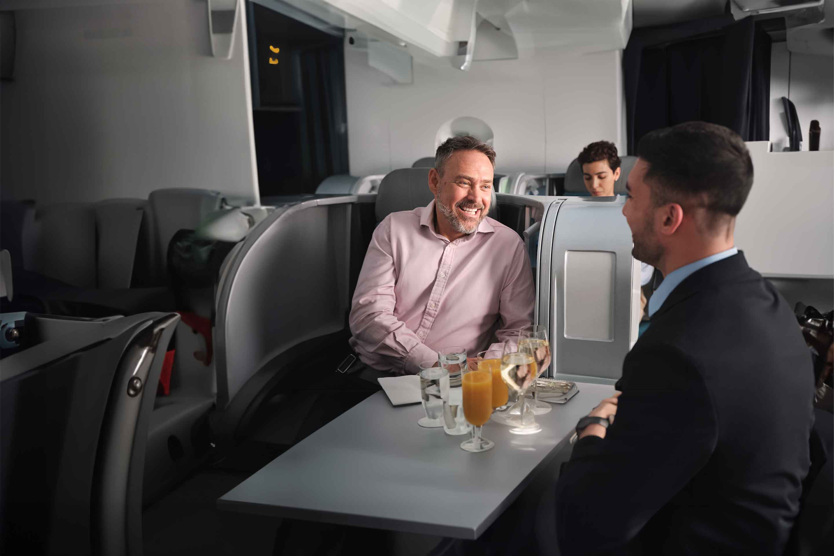 Business Class passenger talking with a cabin crew member