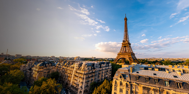 Eiffel Tower in Paris at sunset with light casting over surrounding buildings