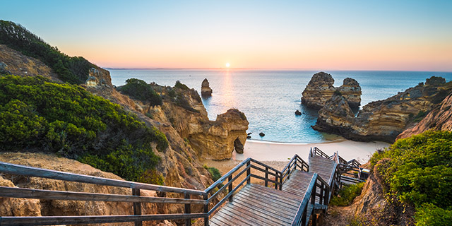 View of walkway down to idyllic beach at sunset in the Algarve